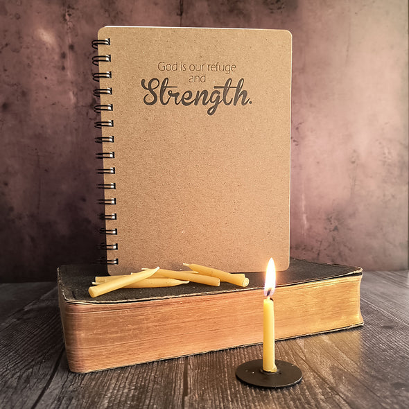 Strength journal and 20 minute candles on an old bible. Lit candle in front