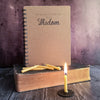 wisdom journal and 20 minute candles on old bible. with lit candle in front