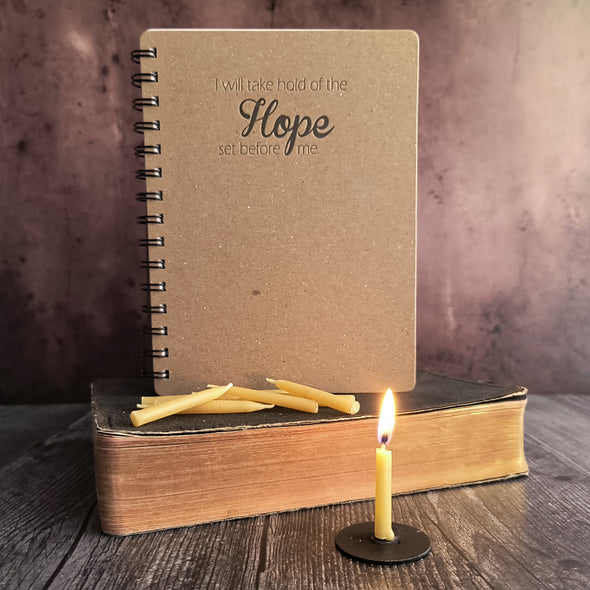 Hope journal and candles on an old bible. 20 minute candle, lit, on a stand